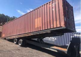 40 ft high cube used shipping container being delivered off a tilt body truck.