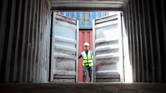 Dock worker opening a shipping container