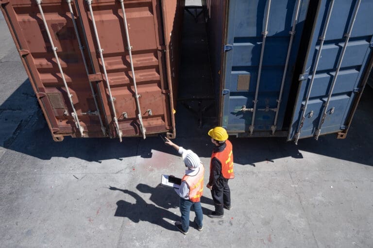 Foreman control loading shipping containers from cargo freight ship for import export, Foreman control industrial container cargo freight ship, Business import and export logistic concept.